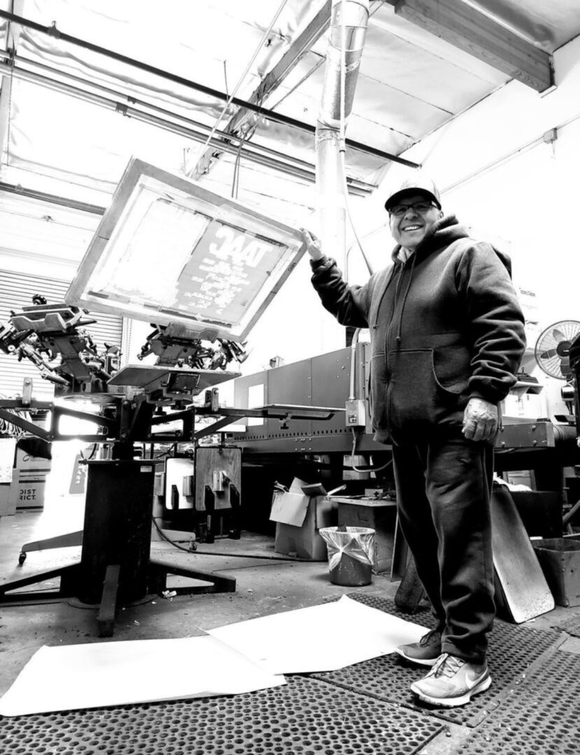 A black and white picture of a man holding a frame