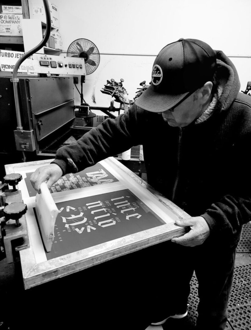 A black and white picture of a man working on a design