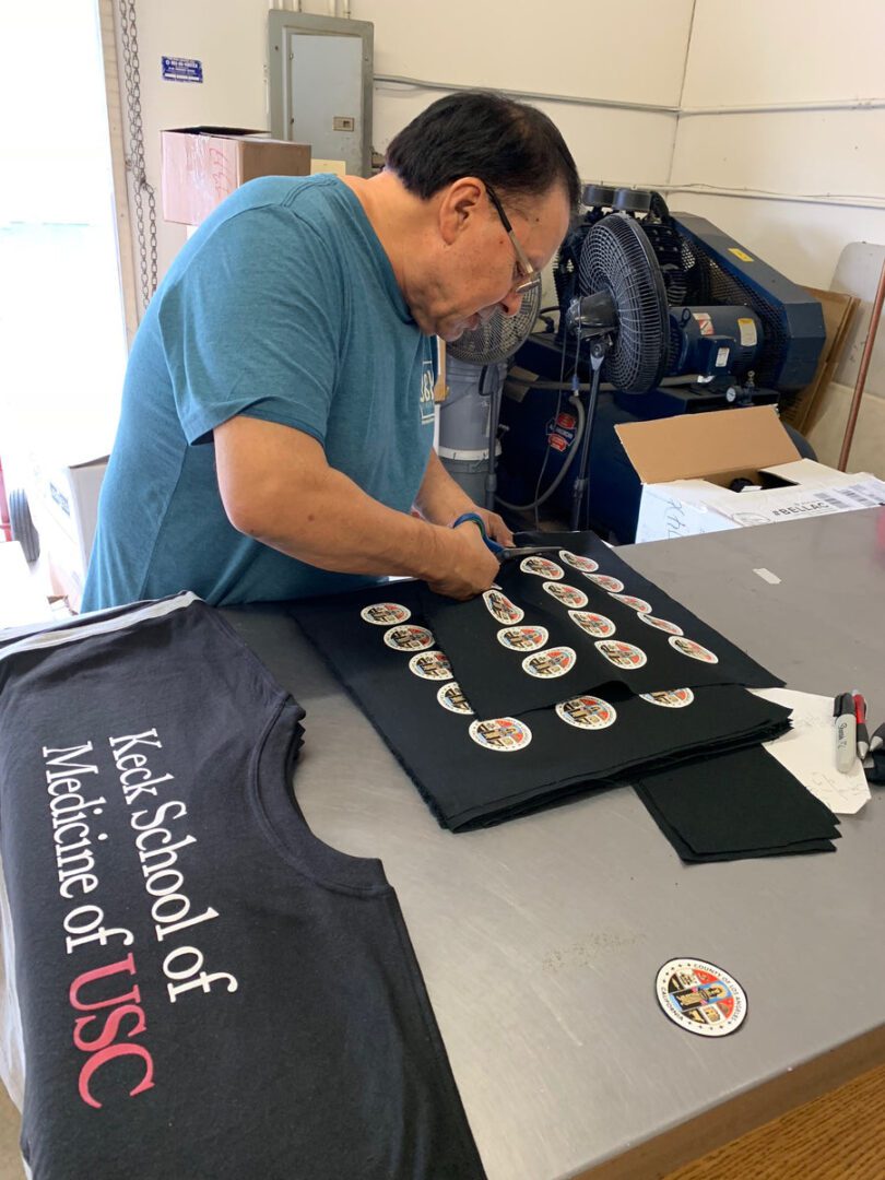 A picture of a man cutting out the prints