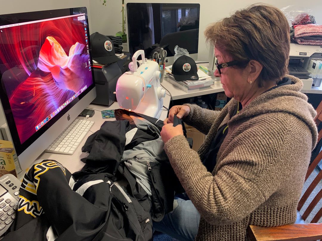 A picture of a woman sewing a piece of cloth
